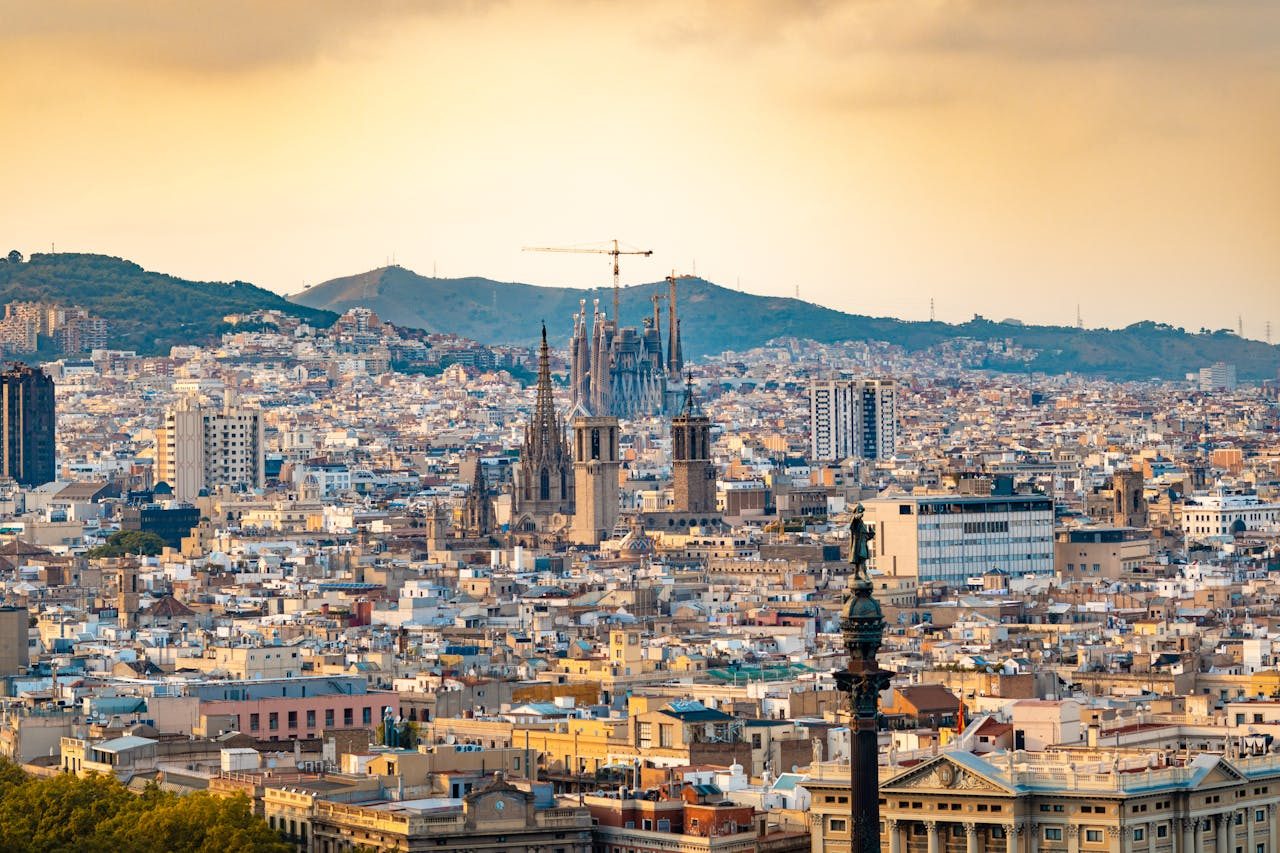Vista de Barcelona al atardecer, con las torres de la Sagrada Família recortadas sobre los tejados del Eixample