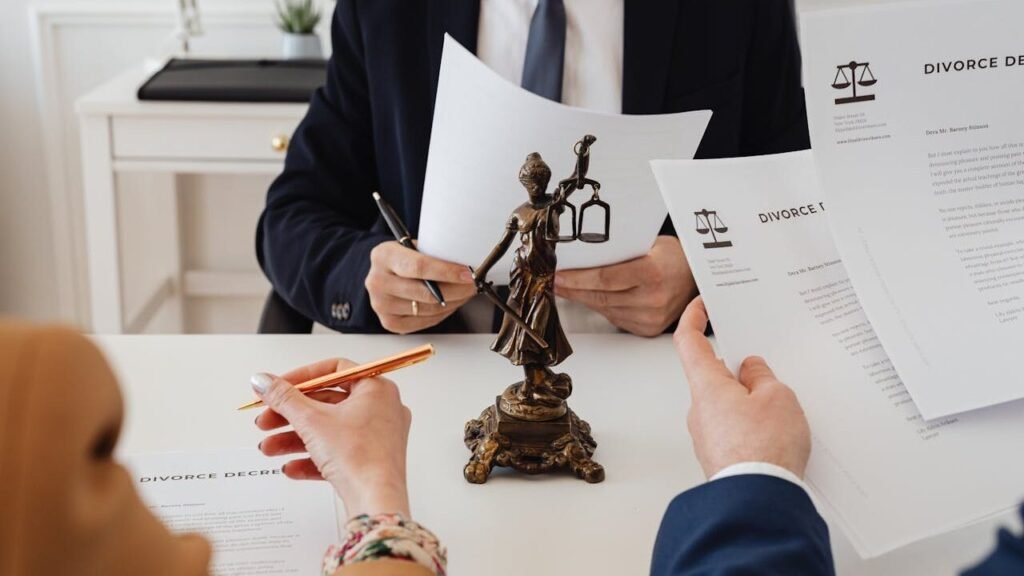 Legal professionals reviewing divorce documents in a law office with a Lady Justice statue.