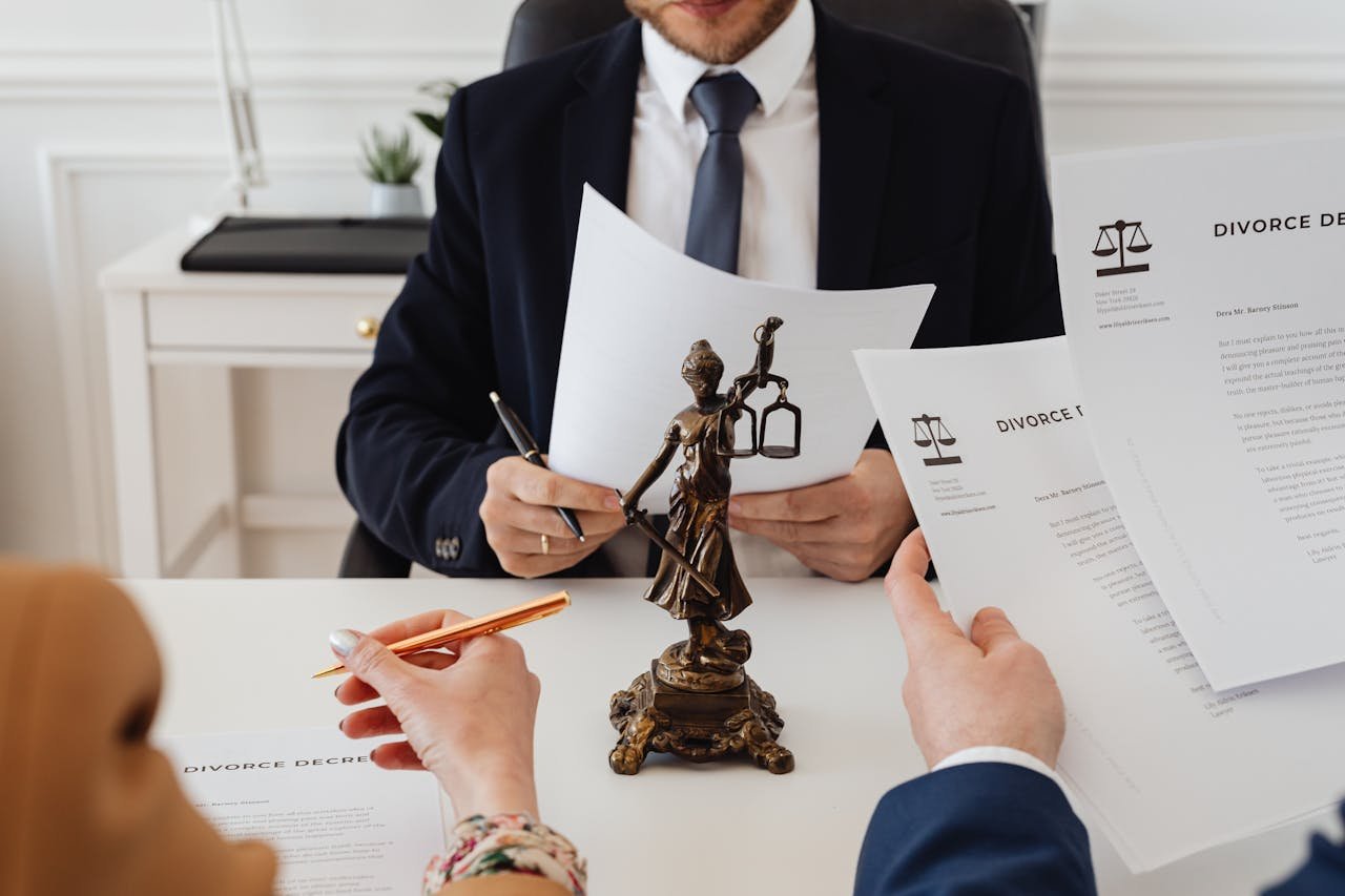 about-us Legal professionals reviewing divorce documents in a law office with a Lady Justice statue.